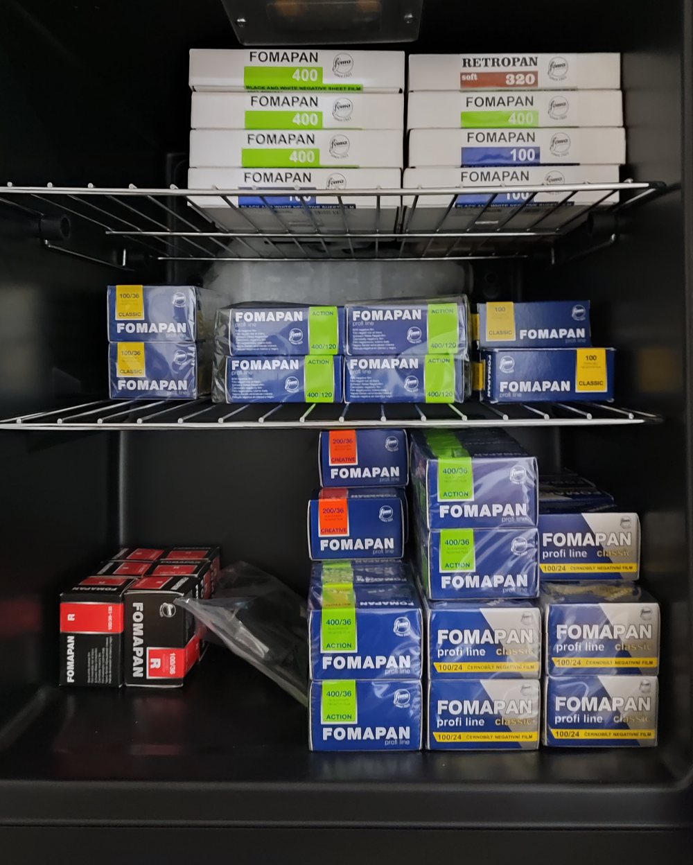 Shelves of Fomapan and Retropan film boxes: sheet film on the top shelf, 120 rolls in the middle and 35mm film below