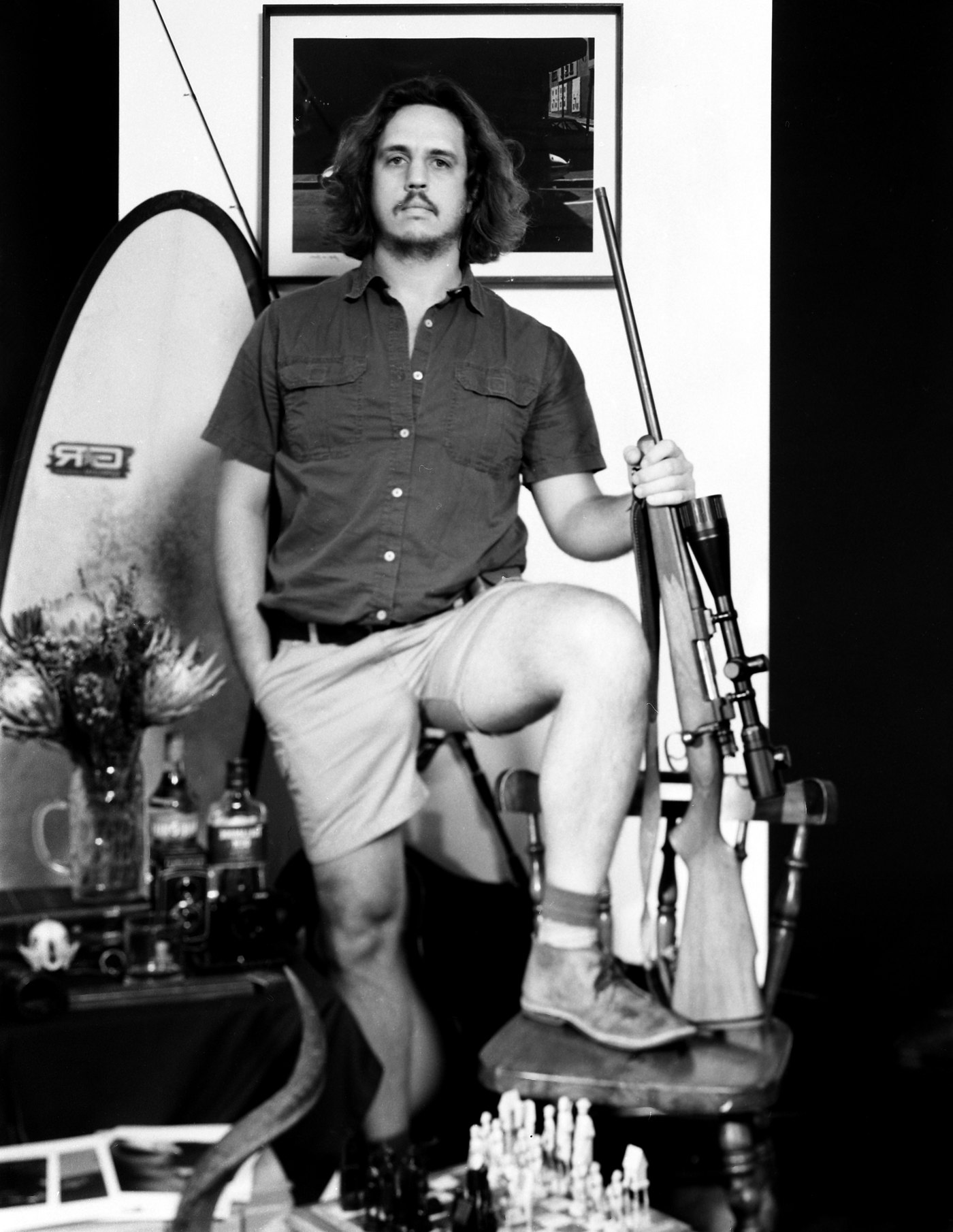 A finished 4x5 portrait of a man standing with one foot on a chair