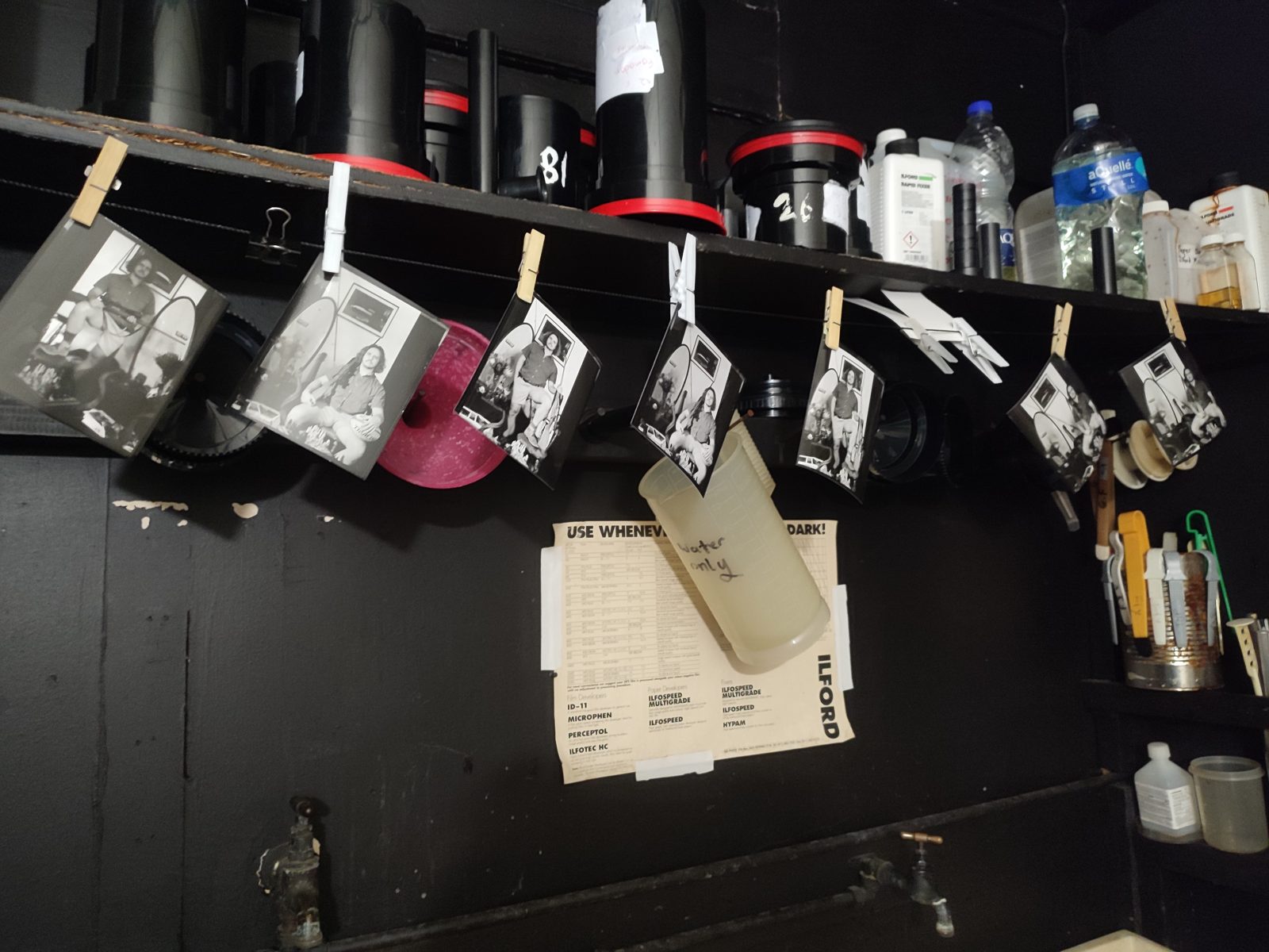 Portrait prints pegged on a line in the darkroom